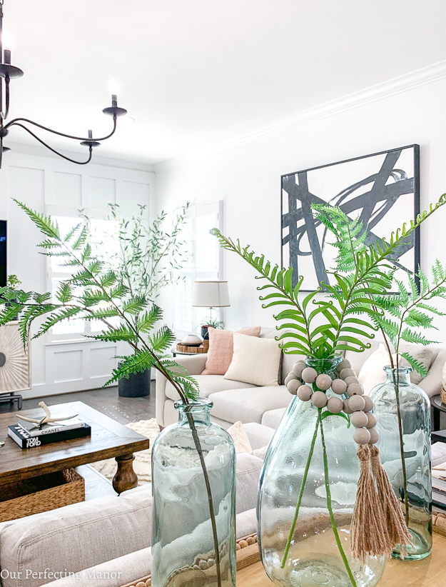 This photo is of three recycled green vases with ferns.